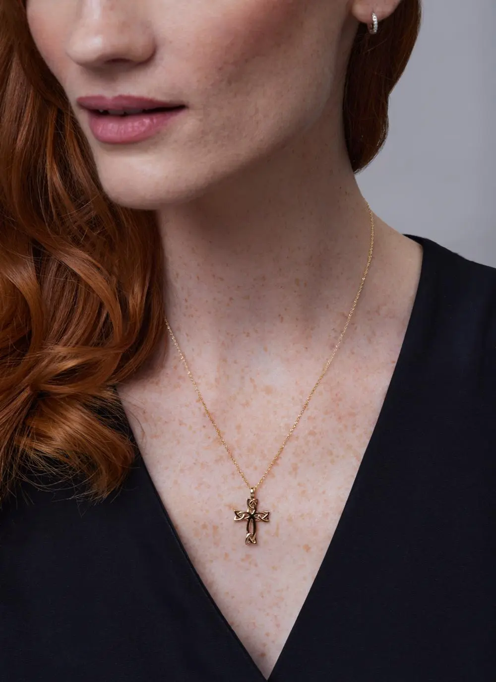 Close up of red haired model wearing 14ct Gold Celtic Cross Trinity Knot Pendant